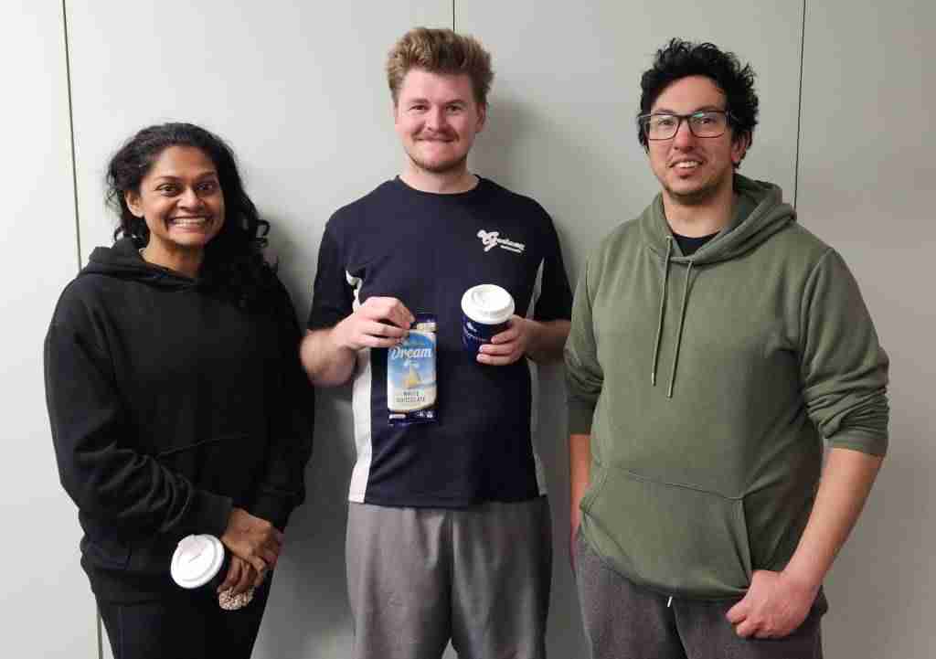 Three Badminton Geelong members holding shuttle tubes at the club